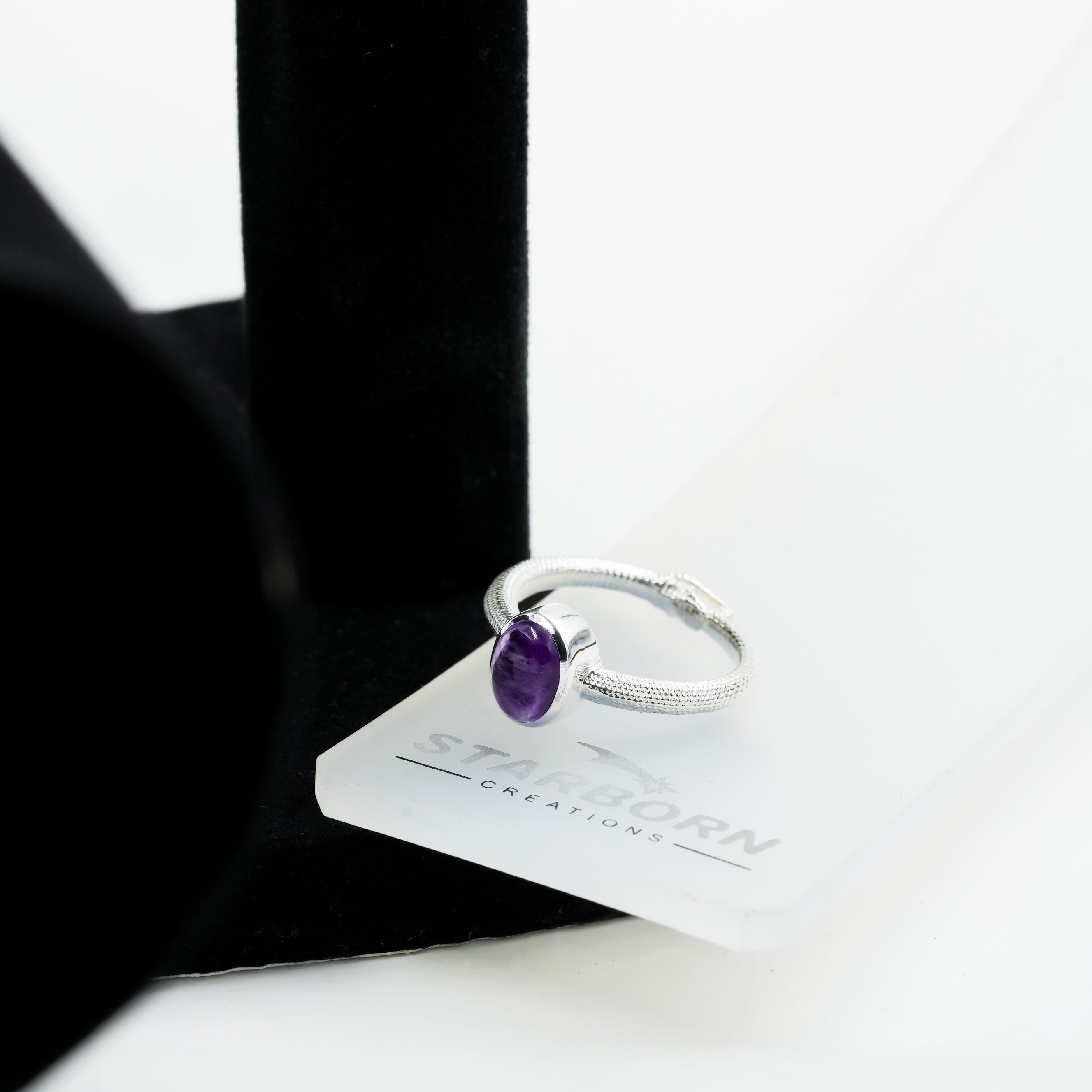Sterling silver ring with an oval amethyst stone and textured ouroboros band